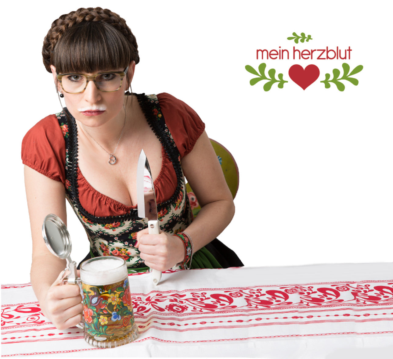 Frau im Dirndl und ein Bier am Tisch