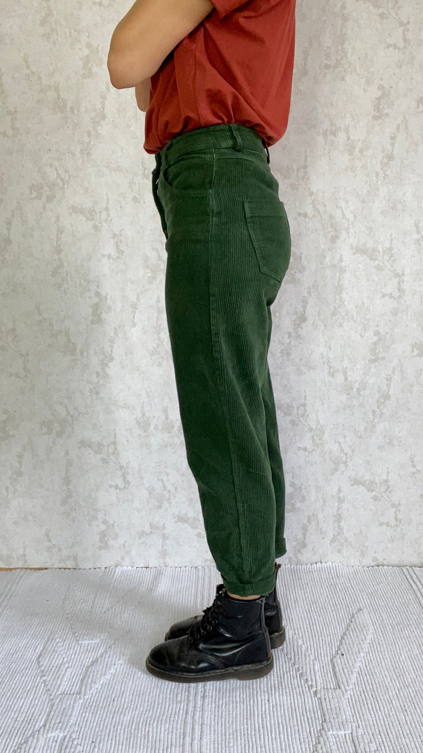 A woman wearing the Cordhose retro 1990 made in Italy pants and a red shirt.