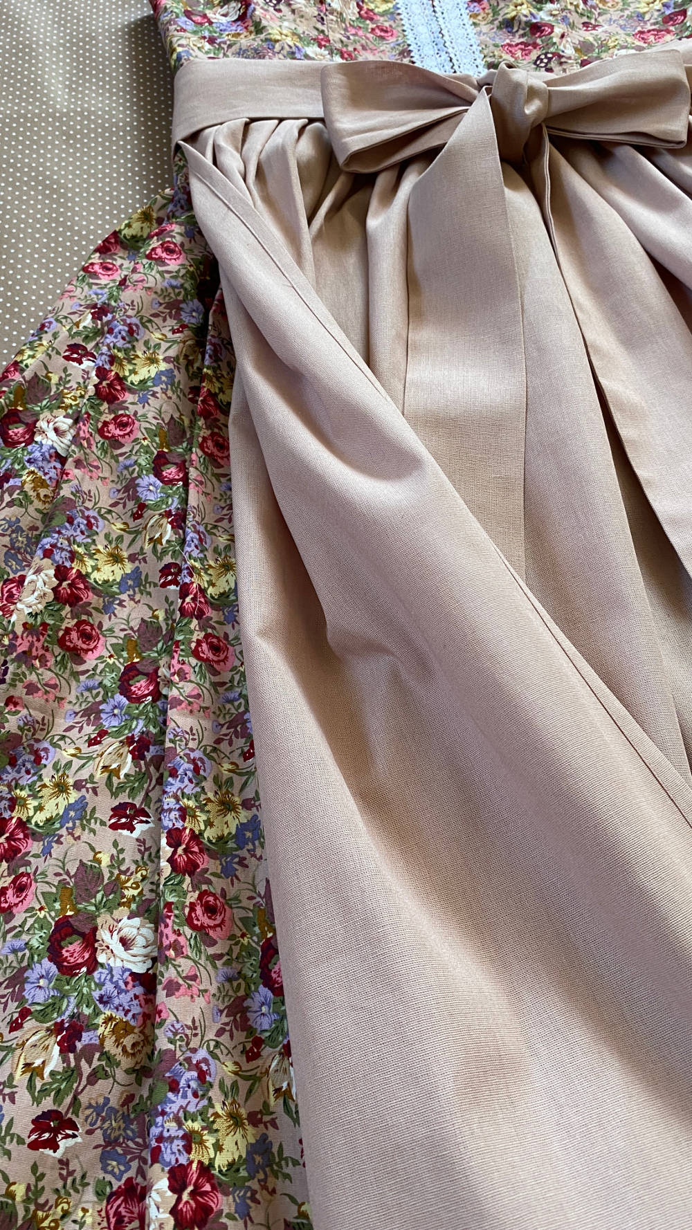 hochgeschlossenes Dirndl in rose Farben mit dunkelroten Rosen.