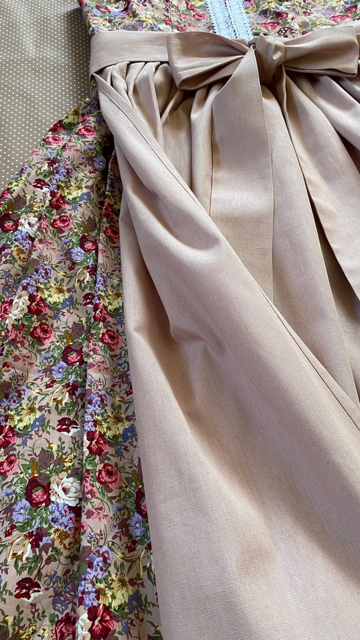 hochgeschlossenes Dirndl in rose Farben mit dunkelroten Rosen.