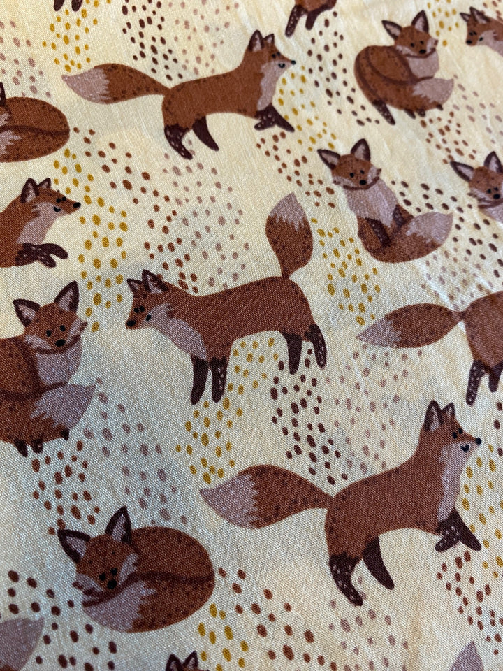 Brauner Fuchs auf hellgelben Hintergrund.