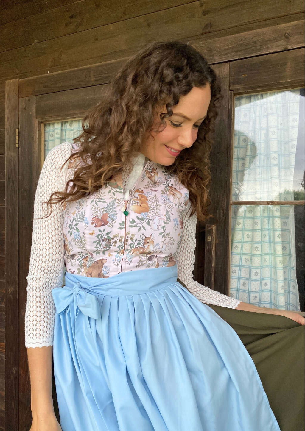 Frau trägt Dirndl mit Waldtier-Print und hellblauer Schürze – Dirndl Waldzauber, limitierte Auflage