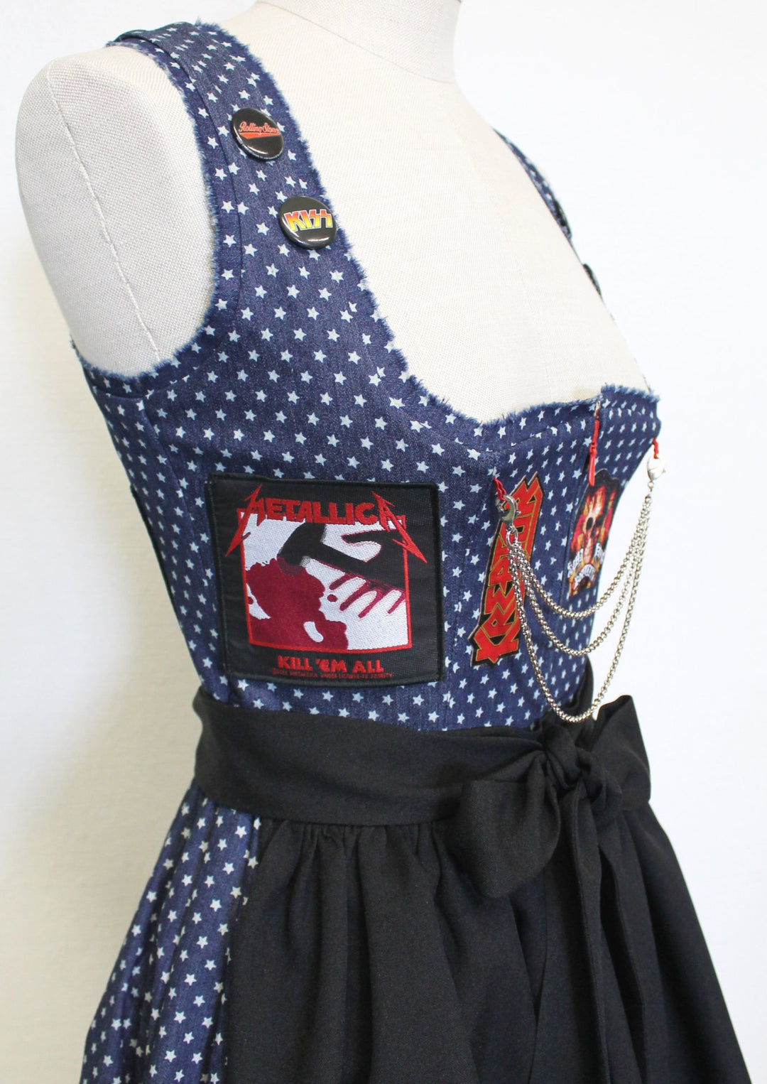 Hier die Seitenansicht von dem Heavy Metal Dirndl. Man sieht hier genau den Aufnäher von Metallica kill em all. Man sieht hier auch noch die Buttons an den Trägern des Dirndls. Es sind Buttons Anstecker wie aus früherer Zeit die man an die Jeans Jacke befestigt hat. 