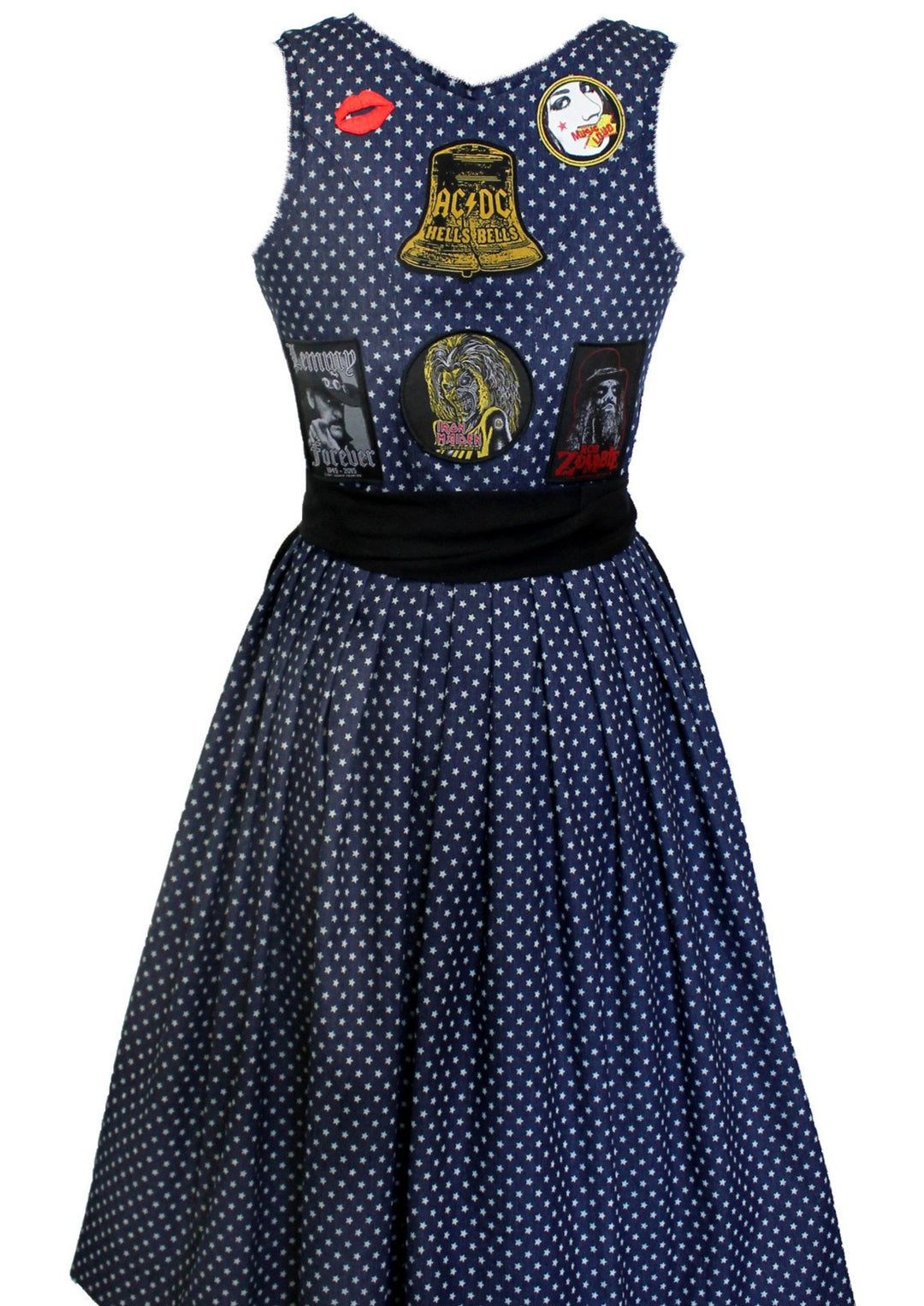 Hier siehtst Du das Jeans Rocker Dirndl von hinten. Man sieht hier genau wie es gemacht wurde. Das komplette Dirndl ist dunkelblau indigo bedruckt mit helleren Sternen. Die Aufnäher wurde auf der Rückseite aufgenäht. Eine große Glocke von ACDC darunter Iron Maiden. Links davon Lemmy und rechts Rob Zombie. Oben an den Schulterblättern sind no name Aufnäher aufgenäht. Einer davon ist ein Kussmund in rot. Die Farben harmonieren super zusammen. 