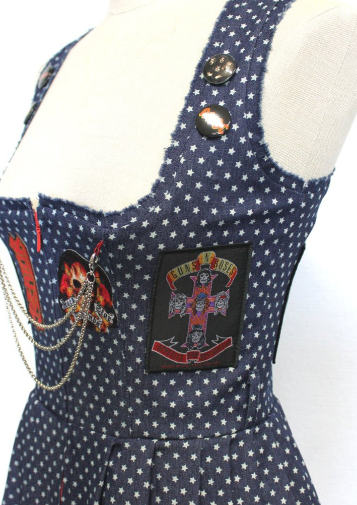 Seitenansicht mit Details von dem Aufnäher der Band Guns n Roses. Darüber an den Dirndlträgern sind die Anstecker Buttons von ADCD und Queen gepinnt. 